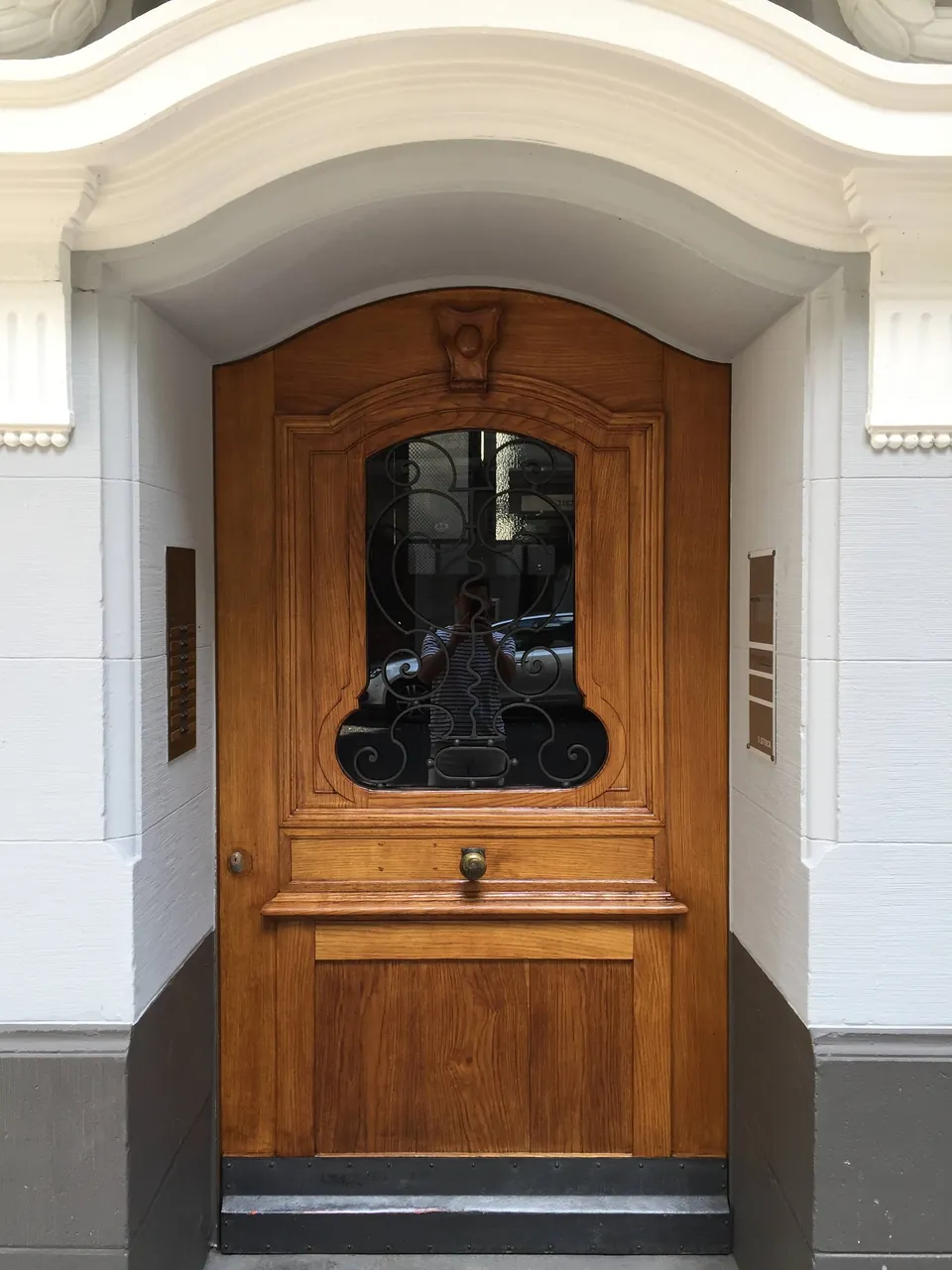 Haustür aus Holz mit Glaseinsatz in einem weiss gestrichenen Eingang