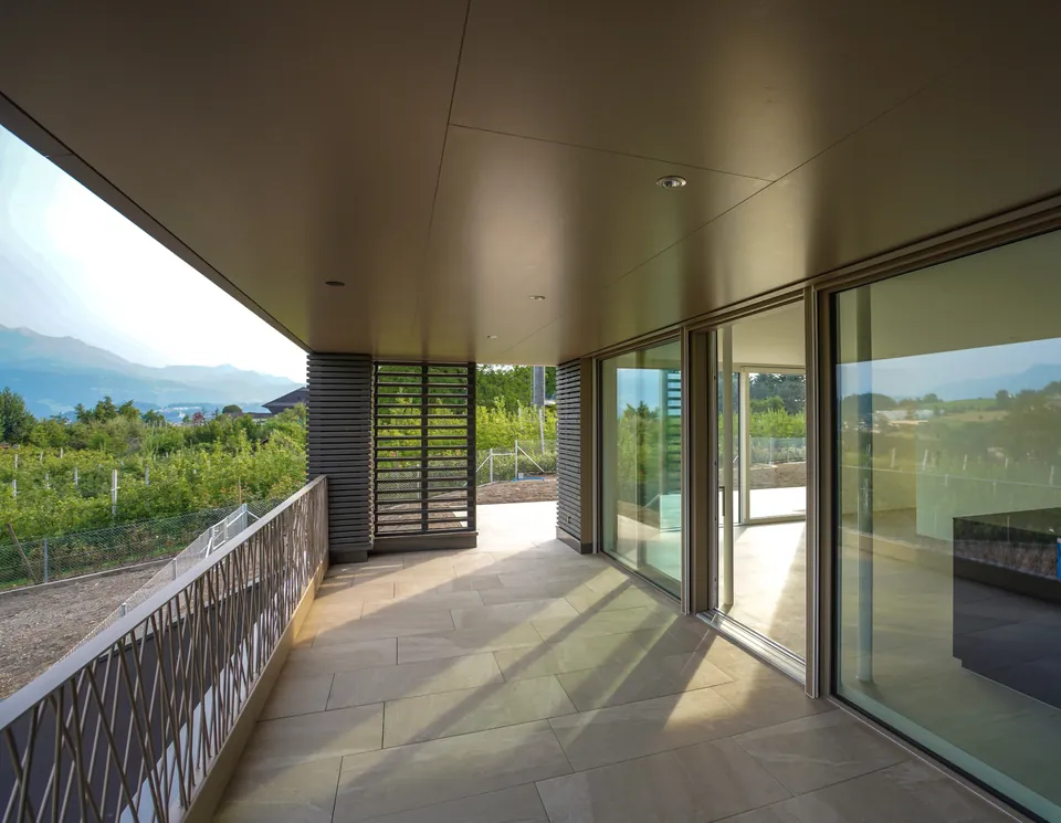 Gedeckter Sitzplatz mit Lattenverkleidung und Glasfront