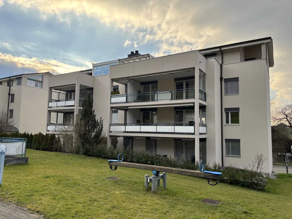 Mehrfamilienhaus mit heller Fassade und Balkonen