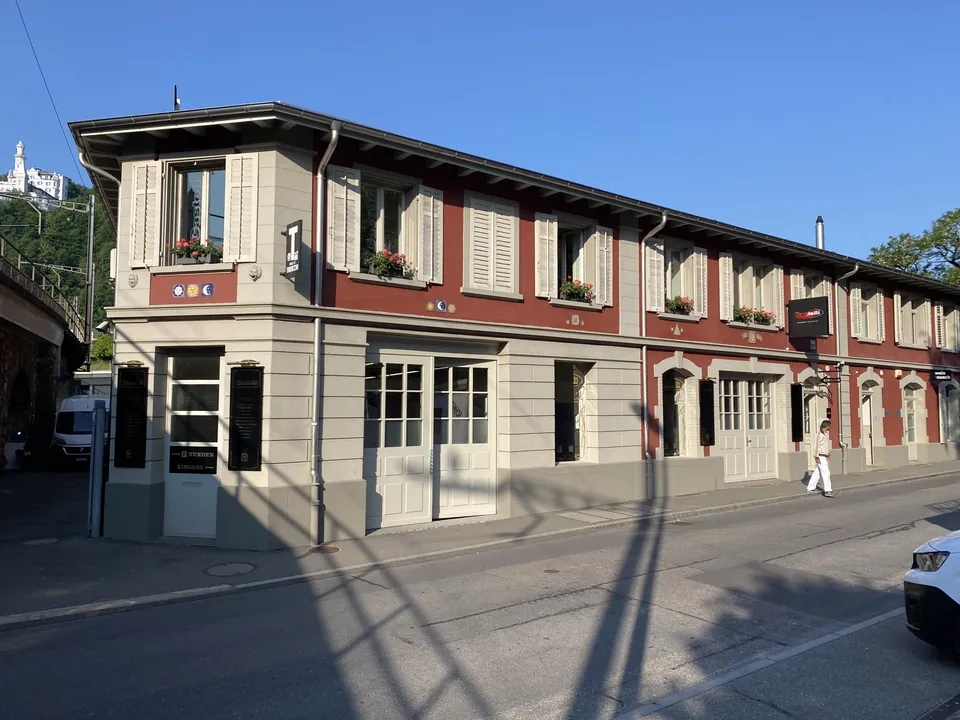 Häuserzeile mit Fassade in Rot und Beige und weissen Fensterläden