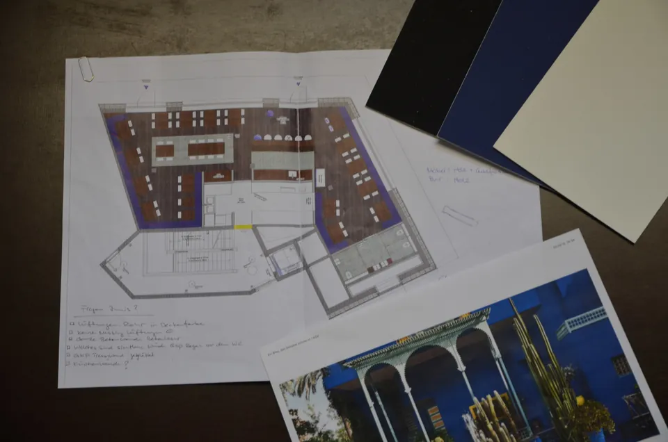 Grundriss mit Farbmustern in Blau und Schwarz und dem Bild eines Raums mit Bogenfenstern