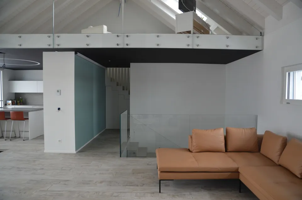 Offener Wohnraum mit Galerie und Sofa in Cognac