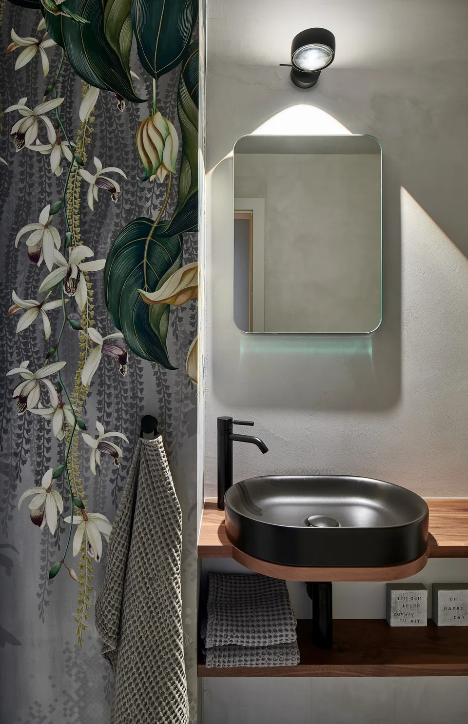 Gäste-WC mit fugenloser Wand, Tapete mit Pflanzenmotiv und schwarzem Waschbecken