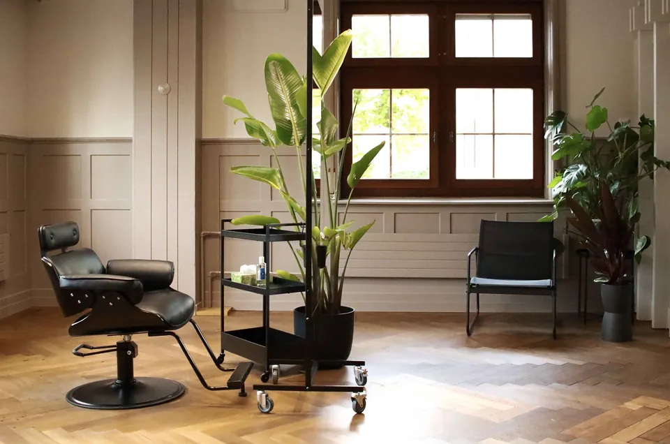 Salon in einem Altbau mit Täfer, Parkett und Pflanzen