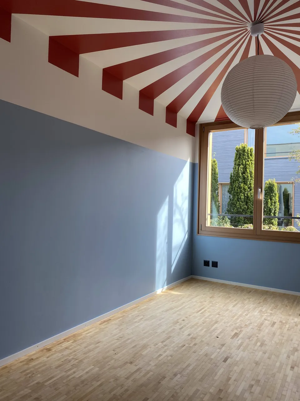 Zimmer mit hellblauen Wänden und rot-weiss gestreifter Decke