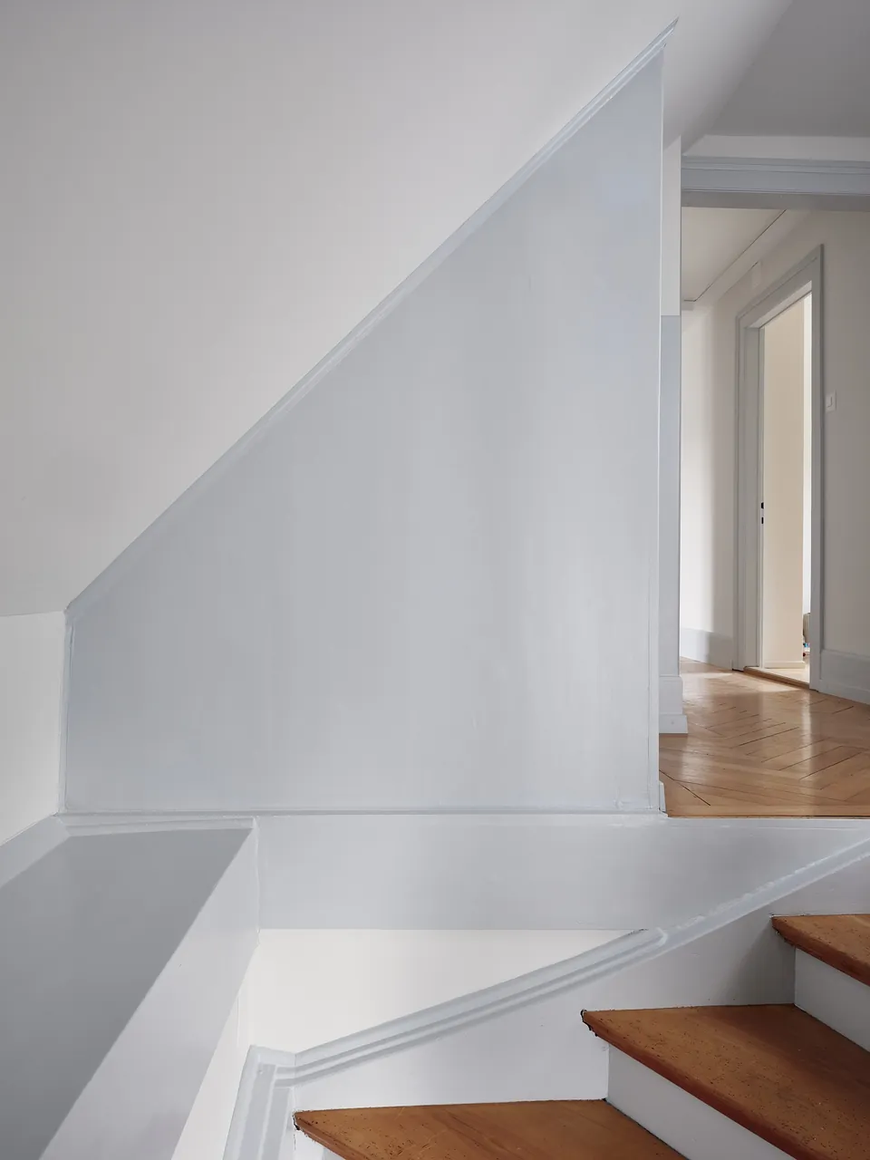 Treppe mit Holzstufen und hellgrauen Wänden