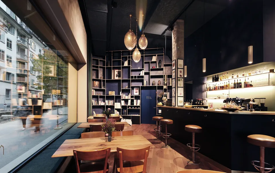Gastraum des Restaurants Majorelle mit dunkelblauen Wänden, Bücherregal und grosser Fensterfront