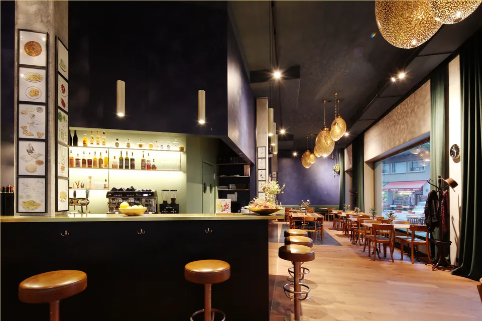 Bar mit Barhockern vor dunkelblauer Wand