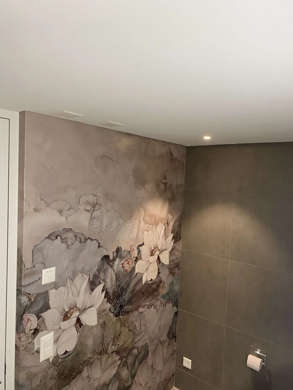 Bad mit Wandbild aus Blüten neben der Badewanne