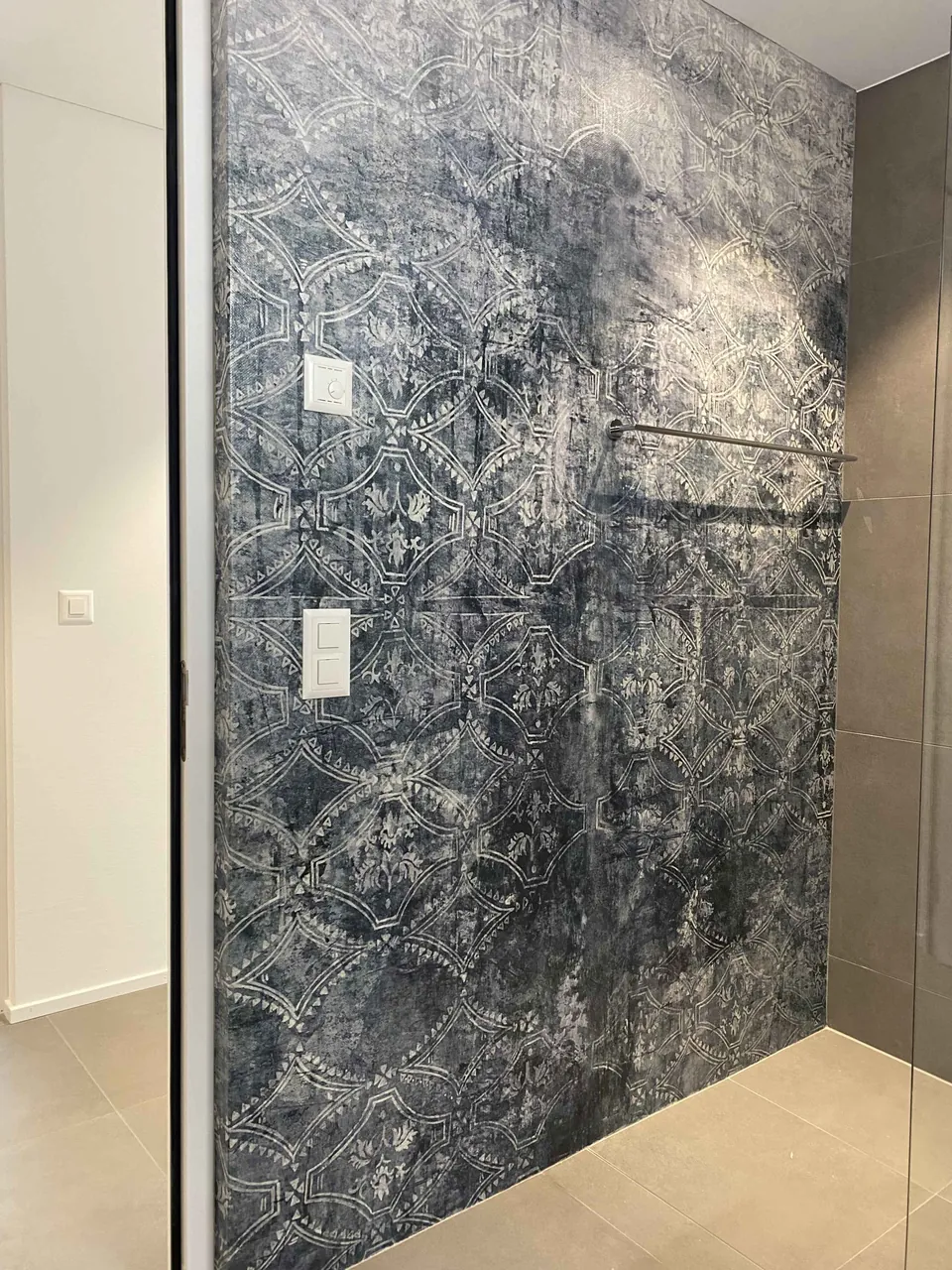 Dusche mit tapezierter Wand in Blautönen
