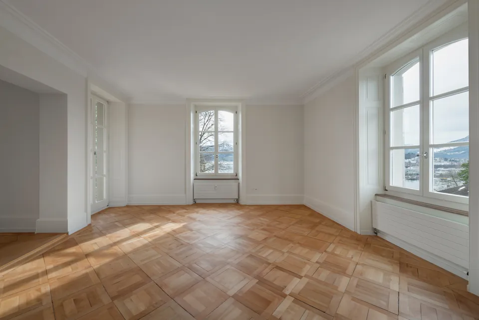 Altbauzimmer mit Parkett und hohen Fenstern