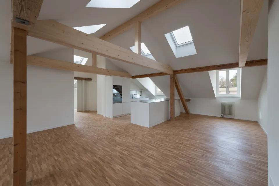 Dachgeschoss mit Holzbalken, Dachfenstern und Küchenzeile