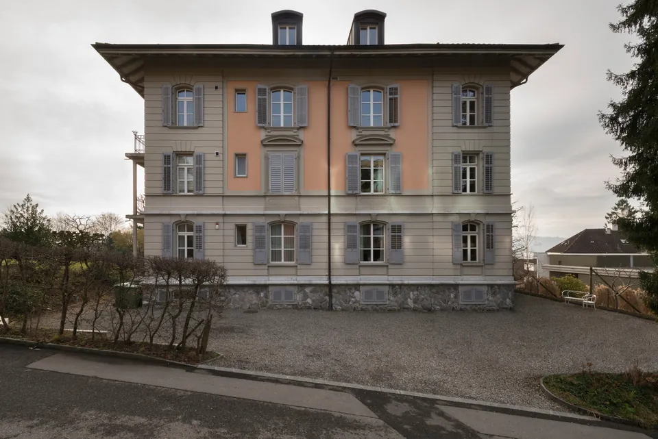 Fassade des Mehrfamilienhauses mit grauen Fensterläden