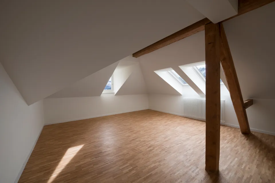 Dachzimmer mit Balken und Sonnenlicht
