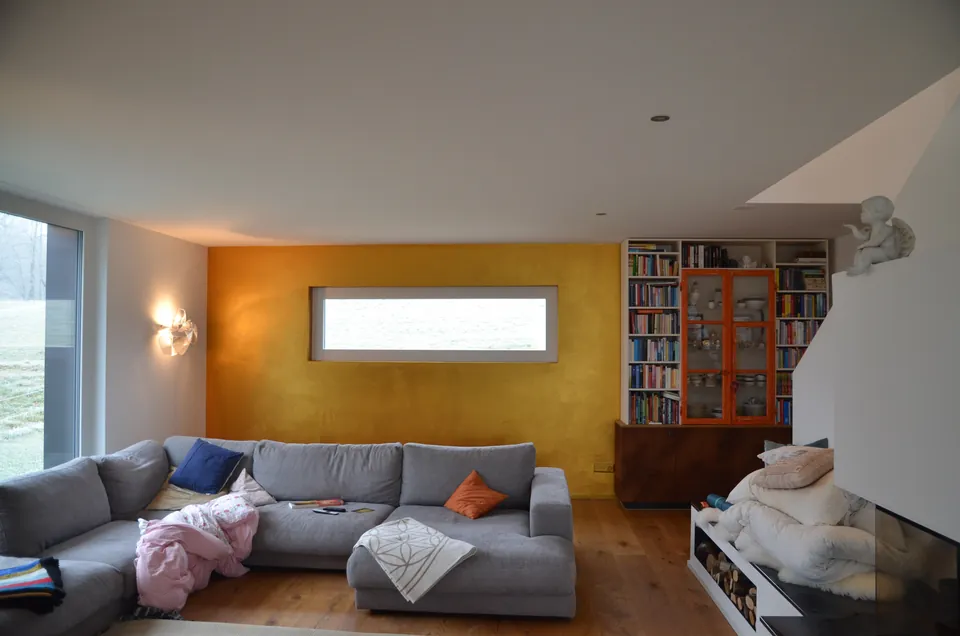 Wohnzimmer mit Sofa vor einer Wand in Goldocker