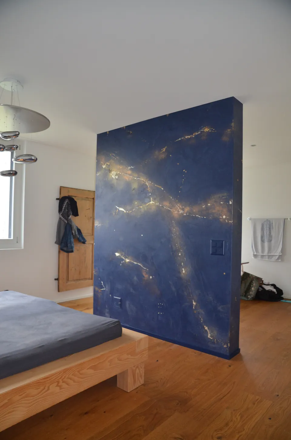 Freistehende blaue Wand mit goldenen Adern im Schlafzimmer
