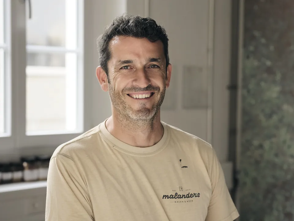 Jasko Sabotic im sandfarbenen Arbeitsshirt von malanders, lachend
